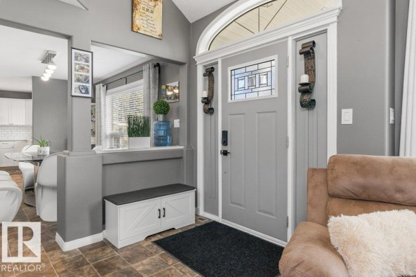Interior view of the grey entryway with a grey door, bench, and view into living room. - #116 53319 Rge Road 14, Rural Parkland County