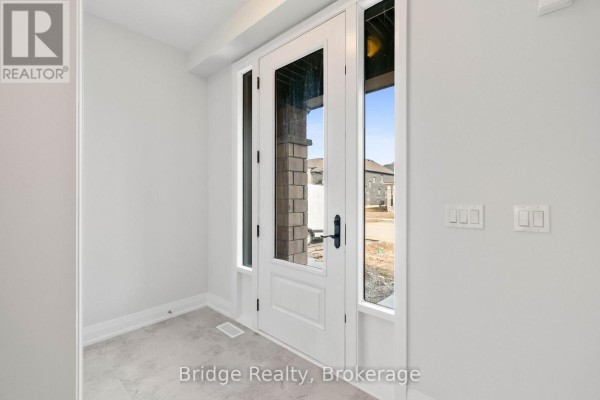 Interior entryway with a white door, large glass panels, and light grey walls. - 116 Cole Terrace, Woodstock