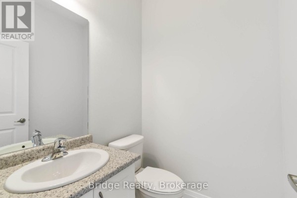 Powder room with white walls, a granite countertop vanity, sink, and white toilet. - 116 Cole Terrace, Woodstock