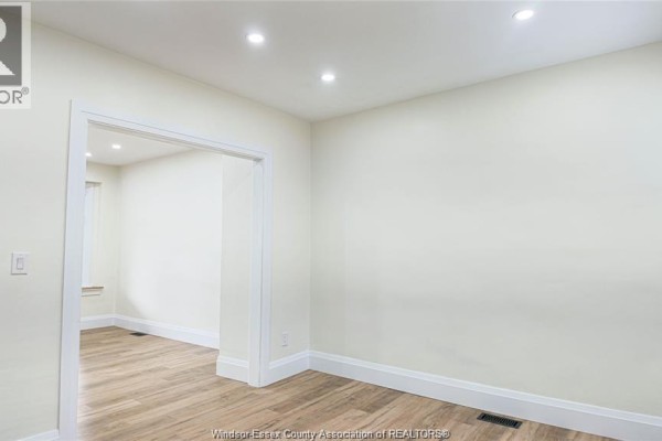 Empty room with light walls, light wood laminate flooring, and an open doorway. - 116 Elm Avenue, Windsor