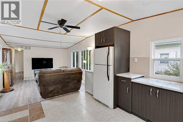 Open concept living area and kitchen with a sofa, television, and ceiling fan. - 116 Franciscus Street, Waterloo
