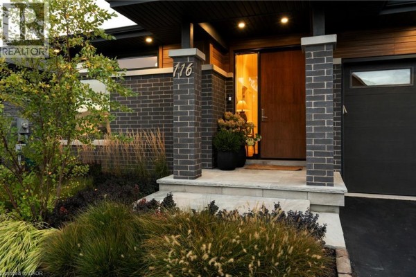 Close-up of the entrance to a house with dark brick pillars and a wooden door. - 116 Lametti Drive, Fonthill