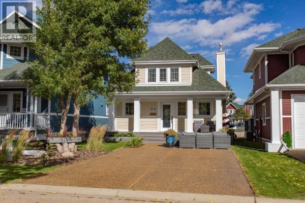 Front view of a two-story beige house with a green roof and driveway. - 116 Marina Bay Court, Sylvan Lake