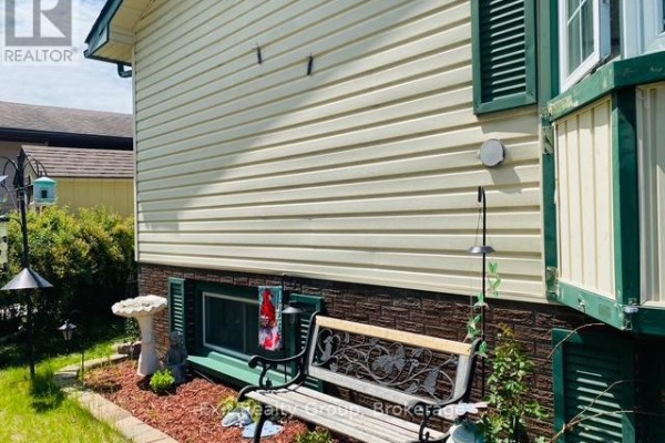 Bedroom with a queen bed, wood-look flooring, and a fan next to a dark green storage unit. - 116 Nicholas Street, Quinte West