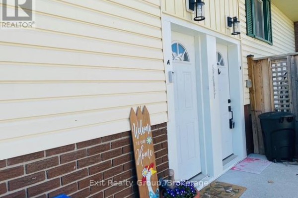 Exterior view of two adjacent white doors, labelled A and B, with welcome mats and fencing. - 116 Nicholas Street, Quinte West