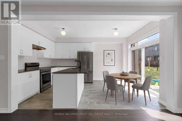 Modern white kitchen with stainless steel appliances and dining area. - 116 Nottingham Road, Barrie