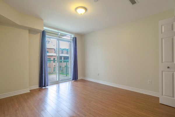 Bedroom with sliding glass doors leading to a balcony and wood flooring. - 1160 Ch. D'aylmer, #202, Gatineau