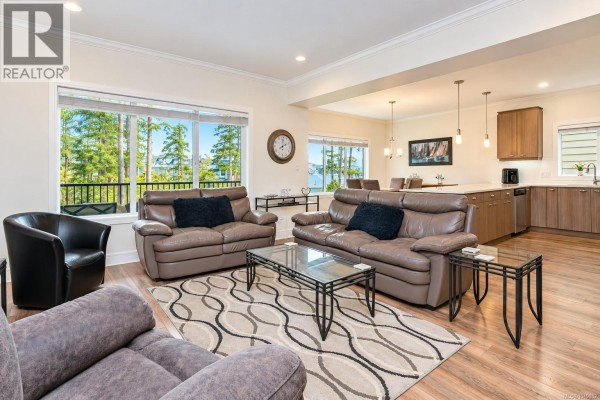 Aerial view of a tan house with a beige garage door on a paved driveway. - 1166 Bombardier Cres, Langford