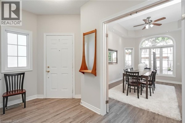 Interior entryway with a white door, wood-look flooring, and a view into a dining room. - 1169 Dorval Drive Unit# 78, Oakville