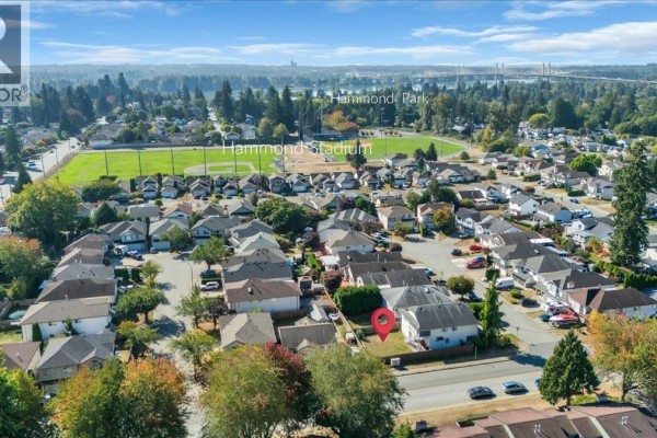 Modern kitchen with white cabinetry, stainless steel appliances, and hardwood flooring. - 11698 206a Street, Maple Ridge