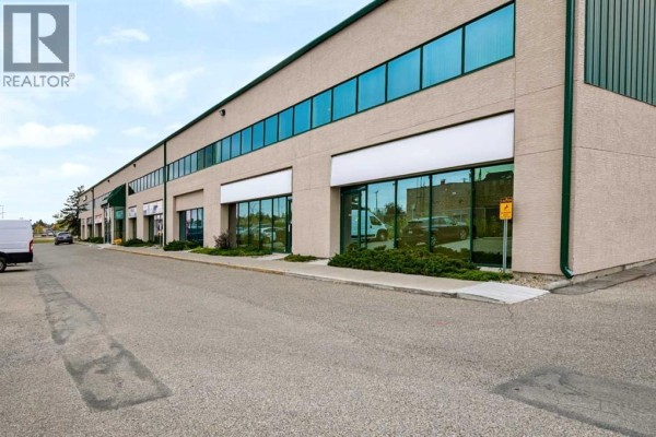 Exterior view of a commercial building with multiple units and large windows. - 117 & 119, 3825 34 Street Ne, Calgary