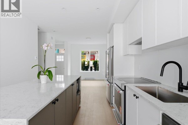 Aerial view of townhouse buildings nestled against a forested mountainside. - 117 1301 Brewster Drive, Coquitlam