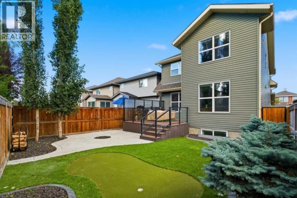 Open concept living area with a white sofa, wood floors, and large windows overlooking greenery. - 117 Auburn Glen Drive Se, Calgary