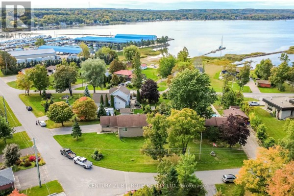 Aerial view of houses in a neighborhood with a marina and lake in the background. - 117 Juneau Road, Tay