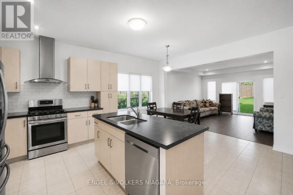 Close-up of the kitchen featuring dark countertops and modern cabinetry. - 117 Juneberry Road, Thorold