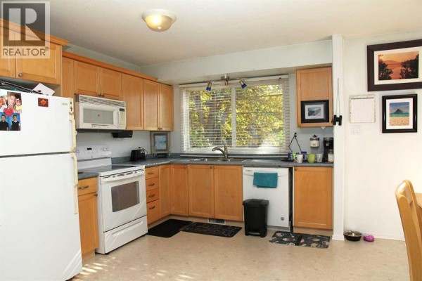 Kitchen with light wood cabinets, white appliances, a sink under a window, and beige linoleum flooring. - 117 Old Jasper Hwy, Marshall
