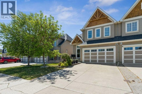 Living room with sofa, armchairs, coffee table, and large window with field view. - 117 Rainbow Falls Boulevard, Chestermere