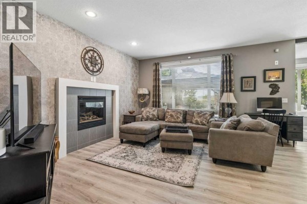 Exterior of beige duplexes with attached garages and gabled architectural details. - 117 Rainbow Falls Boulevard, Chestermere