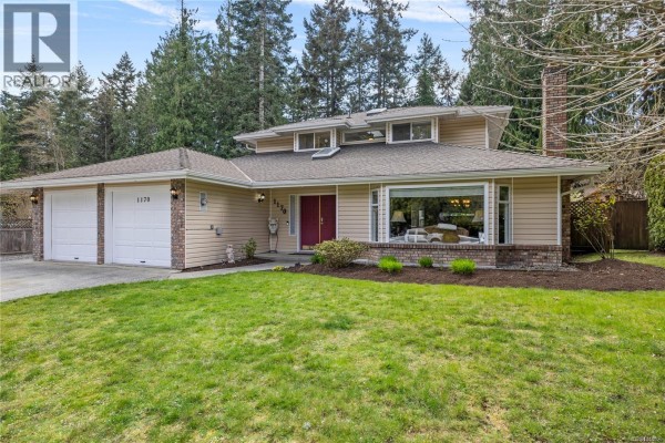 Rear exterior of a beige house with a large patio, chimney, and gazebo. - 1170 Clubhouse Dr, Qualicum Beach