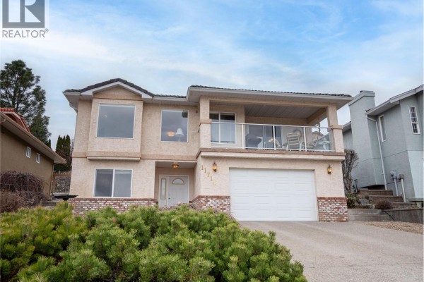 Spacious kitchen with wooden cabinets, stainless steel appliances, and an island with seating - 11714 Quail Ridge Place, Osoyoos
