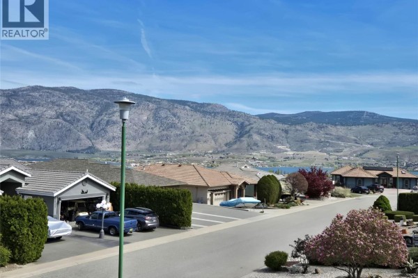 Dining area with a wooden table, chairs, and sliding glass door to the patio - 11714 Quail Ridge Place, Osoyoos