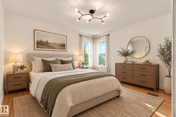 Bedroom with a queen-size bed, nightstands, dresser, mirror, and a unique modern ceiling light. - 11718 129 St Nw, Edmonton