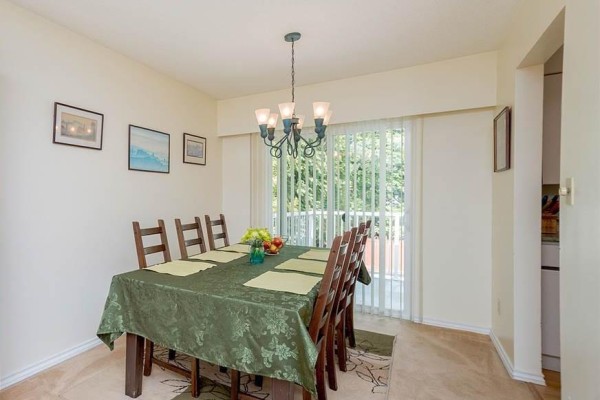 Living room featuring a sectional sofa, carpet, and a fireplace. - 11781 71a Avenue, Delta