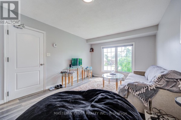 Living room with grey walls, a sofa, coffee table, large window, and a black beanbag chair. - 1179 Simcoe Street S, Oshawa