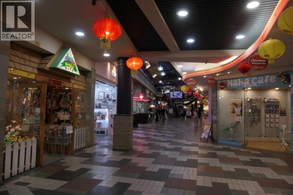 View down a mall walkway with shops, lanterns, and people. - 118, 328 Centre Street Se, Calgary