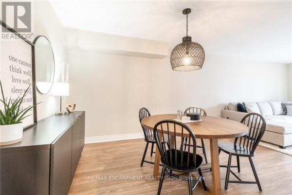 Dining area with wooden table, black chairs, dark sideboard, and woven pendant light. - 118 - 895 Maple Avenue, Burlington