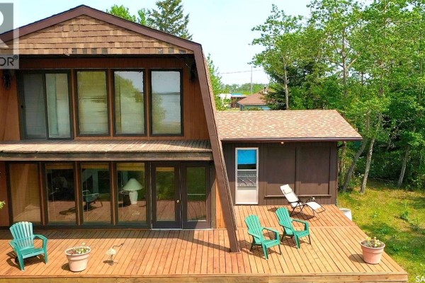 Wooden deck with green chairs and lake view from the rear of the house. - 118-119 Murray Crescent, Fishing Lake