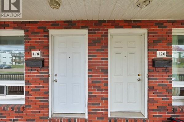 Close-up of two white front doors with mailboxes and brick exterior. - 118-120 Vail Street, Moncton