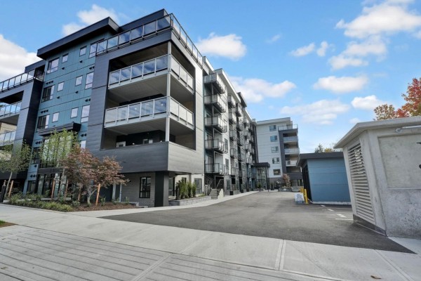Outdoor patio area with a picnic table, blue chairs, and a playground in the background. - 118 33886 Pine Street, Abbotsford