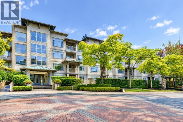 Exterior of the apartment building with a paved circular driveway and manicured hedges. - 118 8180 Jones Road, Richmond