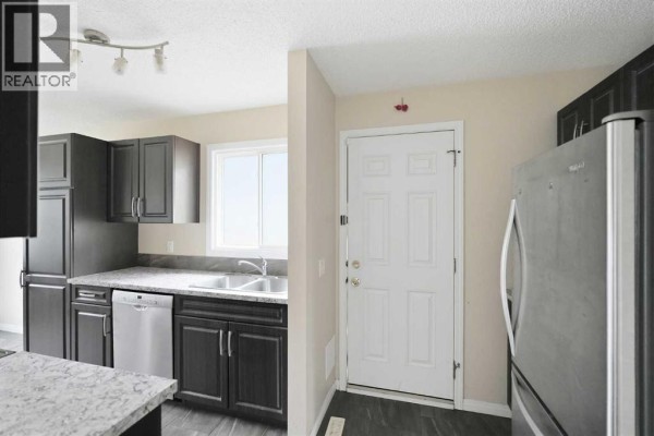 Close-up view of the living room, highlighting the TV setup and seating arrangement. - 118 Dovertree Place Se, Calgary
