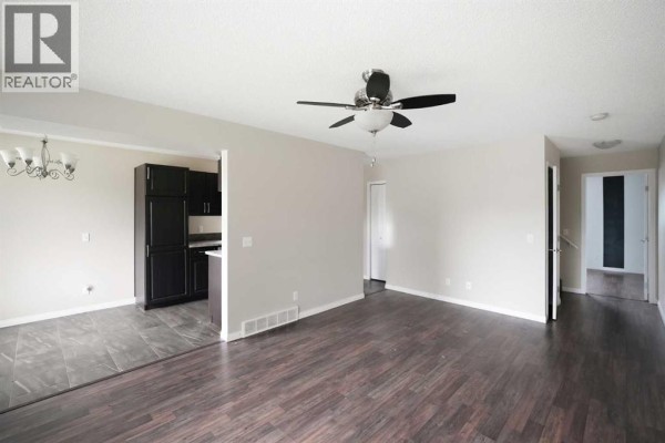Entryway with large windows, front door, and a small shelf against the wall. - 118 Dovertree Place Se, Calgary