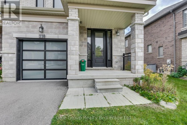 Front entrance porch with stone pillars, glass garage door, and stone facade. - 118 Huntingford Trail W, Woodstock