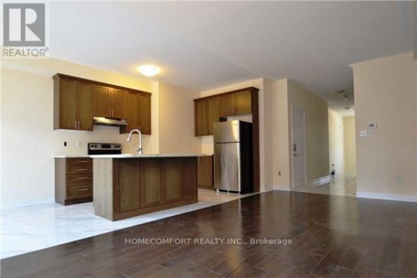 Open concept kitchen with dark wood cabinets, granite island, and stainless steel appliances. - 118 Orchardcroft Road, Oakville