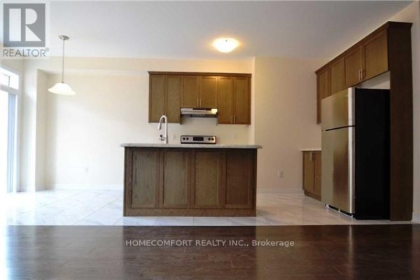 Kitchen island with granite countertop, dark wood cabinets, and stainless steel appliances. - 118 Orchardcroft Road, Oakville