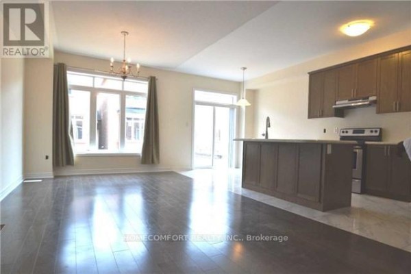 Living room and kitchen area with dark wood floors, large window, and sliding door. - 118 Orchardcroft Road, Oakville