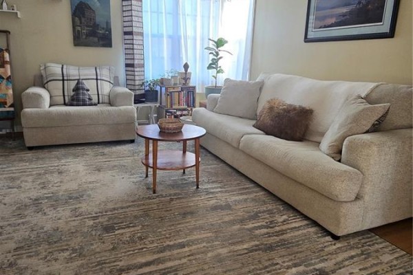 Living room featuring beige sofas, a coffee table, and natural light from the window - 118 Second Street W, Carnduff