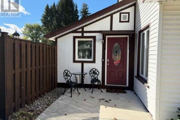 Close-up of a burgundy front door with stained glass and a small patio with two chairs and a table. - 118 Victoria Street E, North Huron
