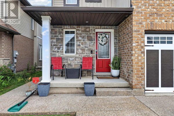 Living room with grey walls, a white fireplace, a large television, and sectional sofa. - 1180 Caen Avenue, Woodstock