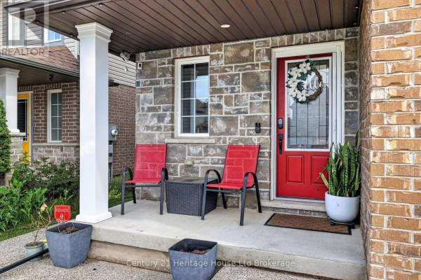 Kitchen island with granite countertop, double sink, and dark wood cabinets, overlooking dining area. - 1180 Caen Avenue, Woodstock