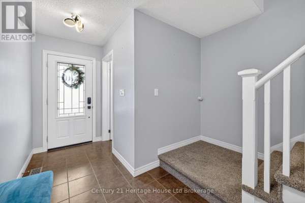 Backyard with a wooden fence, green lawn, a concrete pad, and a small shed. - 1180 Caen Avenue, Woodstock