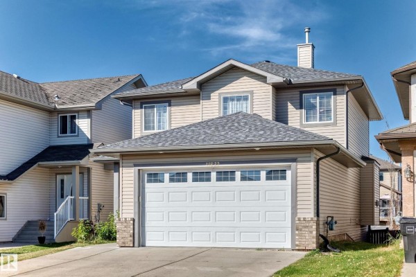 Street view of a two-story beige house with a gray roof and a two-car garage. - 11832 173 Av Nw, Edmonton