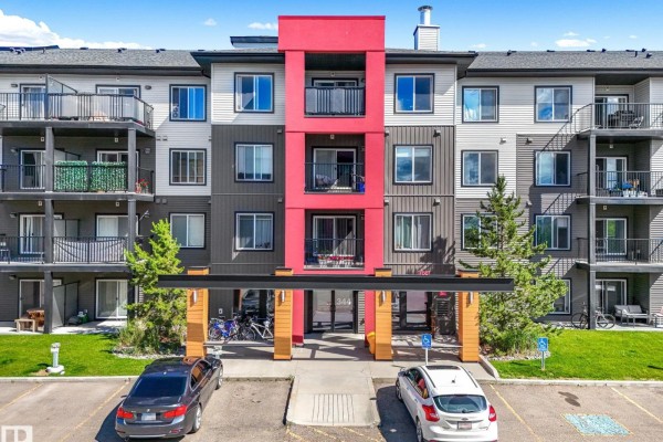 Parking lot with snow, melting ice, footprints, and a yellow vehicle in a snowy environment. - #119 344 Windermere Rd Sw, Edmonton