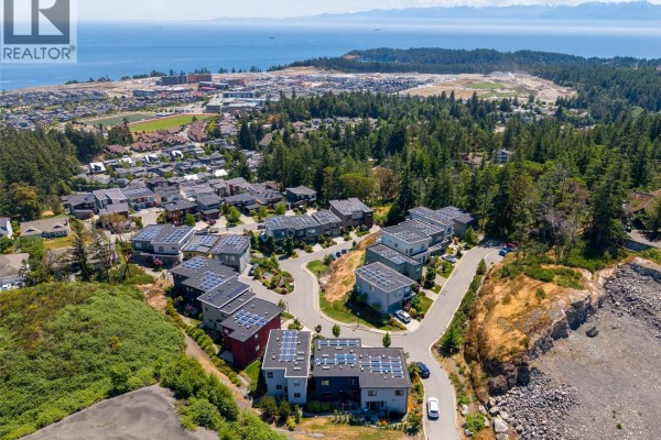 Overhead view of townhouse roofs with multiple solar panels and skylights. - 119 539 Delora Dr, Colwood