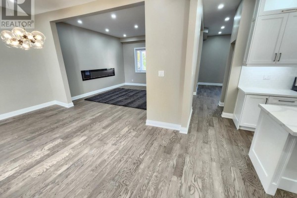 View from the dining area into the living room and down a hallway towards the kitchen. - 119 Colborne Street E, Oshawa