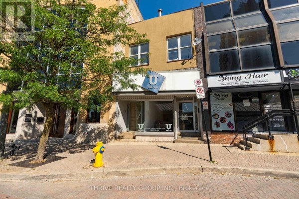 Street level view of a salon and a hair salon with signage and windows. - 119 Dundas Street, London East